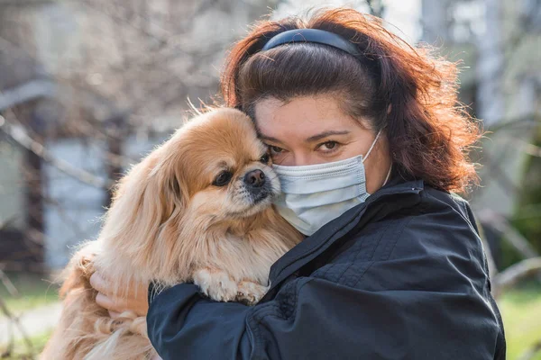 Stop virus ! Woman in Textile protective mask with a dog. Social distance