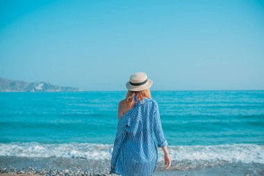 Bahar - Yaz sezonu. Tatil ve seyahat zamanı. Denizde bir kadın, güzel bir manzara.
