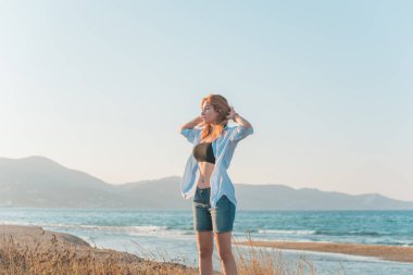 Bahar - Yaz sezonu. Tatil ve seyahat zamanı. Denizde bir kadın, güzel bir manzara.