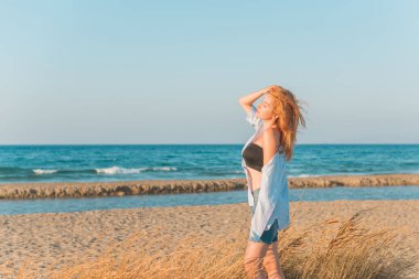 Bahar - Yaz sezonu. Tatil ve seyahat zamanı. Denizde bir kadın, güzel bir manzara.