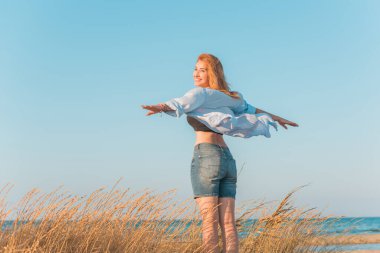 Bahar - Yaz sezonu. Tatil ve seyahat zamanı. Denizde bir kadın, güzel bir manzara.