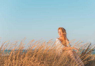 Bahar - Yaz sezonu. Tatil ve seyahat zamanı. Denizde bir kadın, güzel bir manzara.