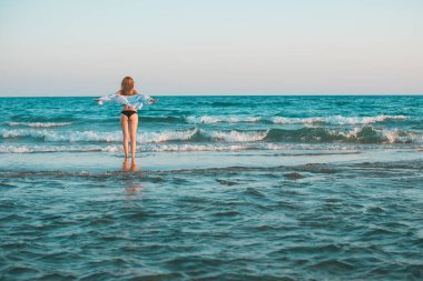Bahar - Yaz sezonu. Tatil ve seyahat zamanı. Denizde bir kadın, güzel bir manzara.