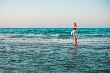 Bahar - Yaz sezonu. Tatil ve seyahat zamanı. Denizde bir kadın, güzel bir manzara.