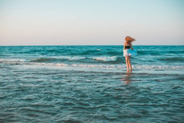 Bahar - Yaz sezonu. Tatil ve seyahat zamanı. Denizde bir kadın, güzel bir manzara.