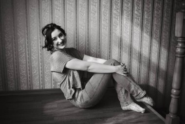 Soluk tenli genç bir bayan. Rahat bir evde eski moda bir model. XI bedenli bir kadın için oldukça sıradan bir eski tarz.