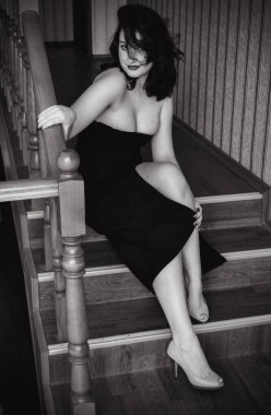 Soluk tenli genç bir bayan. Rahat bir evde eski moda bir model. XI bedenli bir kadın için oldukça sıradan bir eski tarz.