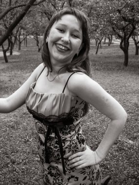 A simple ordinary average girl graduate from an American school high school graduation in the park. Young woman who have a dream.