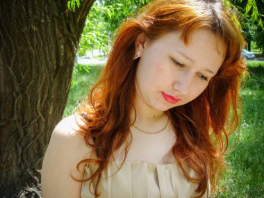 A simple ordinary average girl graduate from an American school high school graduation in the park. Young woman who have a dream. Snapshot with a fashionable vintage effect