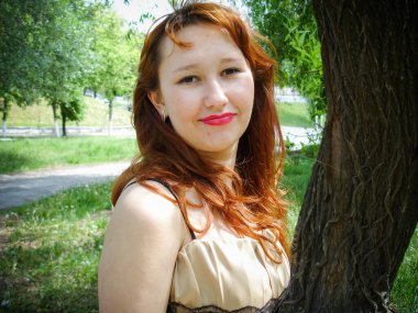 A simple ordinary average girl graduate from an American school high school graduation in the park. Young woman who have a dream. Snapshot with a fashionable vintage effect