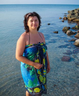 American woman plus a size resting on the seashore early in the morning enjoying the sun at the resort