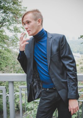 Young guy walking around and smoking, Student at city street, college or university lifestyle time