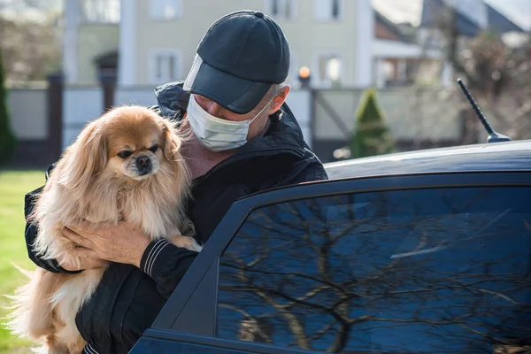 Virus concept. Senior man in mask with his dog, risk for health, seasonal problem