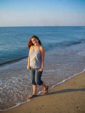 Arap genç bir kız, dolgun kalçalı, deniz kenarında dinleniyor, vücudunu gösteriyor, artı beden ölçülerinde bir kız.