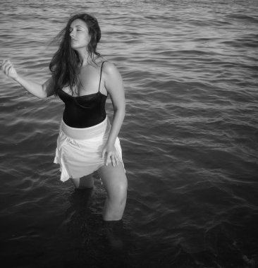 Arap genç bir kız, dolgun kalçalı, deniz kenarında dinleniyor, vücudunu gösteriyor, artı beden ölçülerinde bir kız.