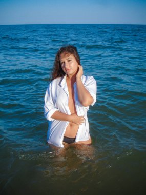 Arap genç bir kız, dolgun kalçalı, deniz kenarında dinleniyor, vücudunu gösteriyor, artı beden ölçülerinde bir kız.