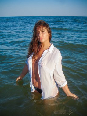 Arap genç bir kız, dolgun kalçalı, deniz kenarında dinleniyor, vücudunu gösteriyor, artı beden ölçülerinde bir kız.