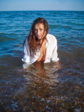 Arap genç bir kız, dolgun kalçalı, deniz kenarında dinleniyor, vücudunu gösteriyor, artı beden ölçülerinde bir kız.