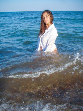 Arap genç bir kız, dolgun kalçalı, deniz kenarında dinleniyor, vücudunu gösteriyor, artı beden ölçülerinde bir kız.