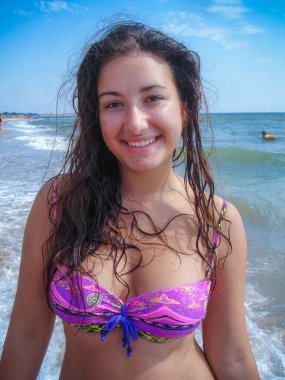 Arap genç bir kız, dolgun kalçalı, deniz kenarında dinleniyor, vücudunu gösteriyor, artı beden ölçülerinde bir kız.