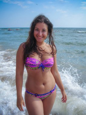 Arap genç bir kız, dolgun kalçalı, deniz kenarında dinleniyor, vücudunu gösteriyor, artı beden ölçülerinde bir kız.