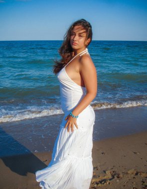 Arap genç bir kız, dolgun kalçalı, deniz kenarında dinleniyor, vücudunu gösteriyor, artı beden ölçülerinde bir kız.