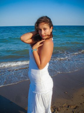 Arap genç bir kız, dolgun kalçalı, deniz kenarında dinleniyor, vücudunu gösteriyor, artı beden ölçülerinde bir kız.