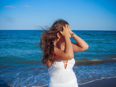 Arap genç bir kız, dolgun kalçalı, deniz kenarında dinleniyor, vücudunu gösteriyor, artı beden ölçülerinde bir kız.