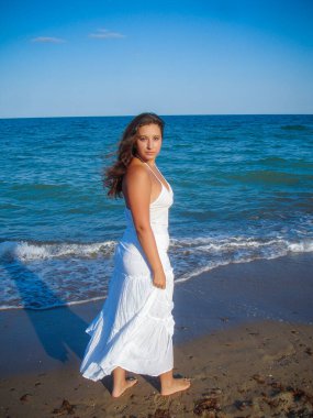 Arap genç bir kız, dolgun kalçalı, deniz kenarında dinleniyor, vücudunu gösteriyor, artı beden ölçülerinde bir kız.