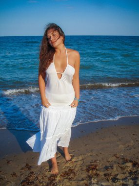 Arap genç bir kız, dolgun kalçalı, deniz kenarında dinleniyor, vücudunu gösteriyor, artı beden ölçülerinde bir kız.