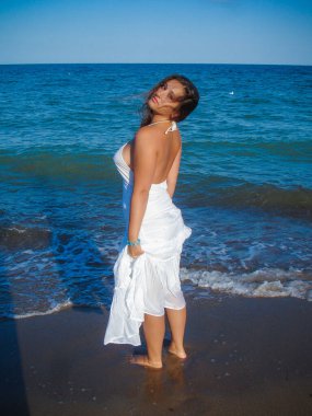 Arap genç bir kız, dolgun kalçalı, deniz kenarında dinleniyor, vücudunu gösteriyor, artı beden ölçülerinde bir kız.