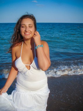 Arap genç bir kız, dolgun kalçalı, deniz kenarında dinleniyor, vücudunu gösteriyor, artı beden ölçülerinde bir kız.