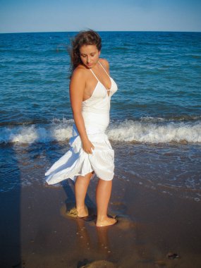 Arap genç bir kız, dolgun kalçalı, deniz kenarında dinleniyor, vücudunu gösteriyor, artı beden ölçülerinde bir kız.