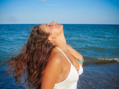 Arap genç bir kız, dolgun kalçalı, deniz kenarında dinleniyor, vücudunu gösteriyor, artı beden ölçülerinde bir kız.