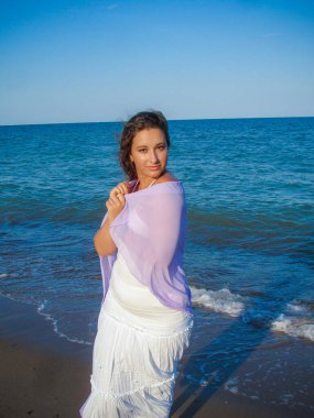 Arap genç bir kız, dolgun kalçalı, deniz kenarında dinleniyor, vücudunu gösteriyor, artı beden ölçülerinde bir kız.