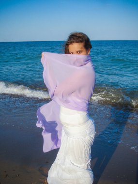 Arap genç bir kız, dolgun kalçalı, deniz kenarında dinleniyor, vücudunu gösteriyor, artı beden ölçülerinde bir kız.