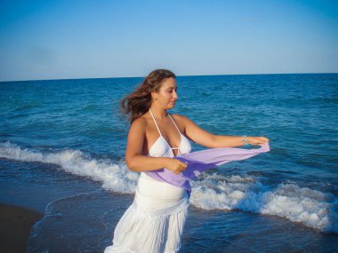 Arap genç bir kız, dolgun kalçalı, deniz kenarında dinleniyor, vücudunu gösteriyor, artı beden ölçülerinde bir kız.