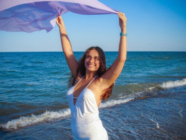 Arap genç bir kız, dolgun kalçalı, deniz kenarında dinleniyor, vücudunu gösteriyor, artı beden ölçülerinde bir kız.