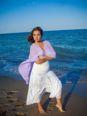 Arap genç bir kız, dolgun kalçalı, deniz kenarında dinleniyor, vücudunu gösteriyor, artı beden ölçülerinde bir kız.