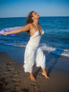 Arap genç bir kız, dolgun kalçalı, deniz kenarında dinleniyor, vücudunu gösteriyor, artı beden ölçülerinde bir kız.