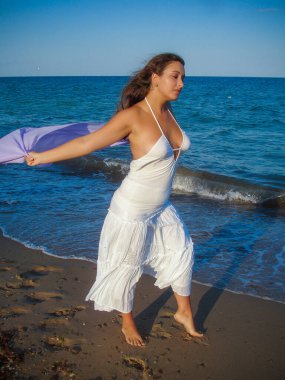 Arap genç bir kız, dolgun kalçalı, deniz kenarında dinleniyor, vücudunu gösteriyor, artı beden ölçülerinde bir kız.