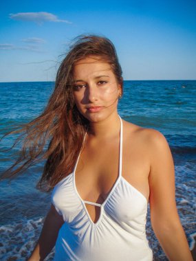 Arap genç bir kız, dolgun kalçalı, deniz kenarında dinleniyor, vücudunu gösteriyor, artı beden ölçülerinde bir kız.