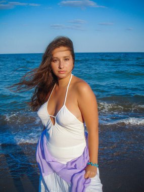 Arap genç bir kız, dolgun kalçalı, deniz kenarında dinleniyor, vücudunu gösteriyor, artı beden ölçülerinde bir kız.