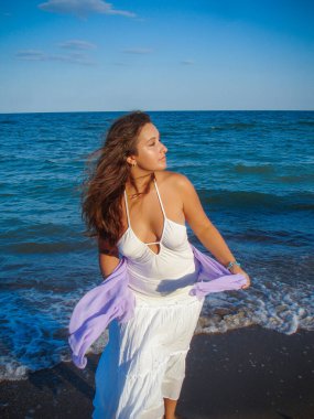 Arap genç bir kız, dolgun kalçalı, deniz kenarında dinleniyor, vücudunu gösteriyor, artı beden ölçülerinde bir kız.