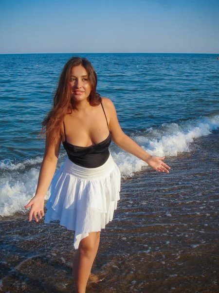 Arap genç bir kız, dolgun kalçalı, deniz kenarında dinleniyor, vücudunu gösteriyor, artı beden ölçülerinde bir kız.