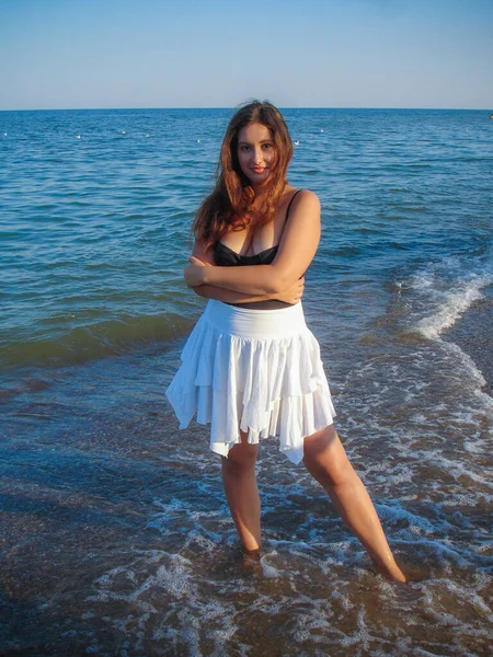 Arap genç bir kız, dolgun kalçalı, deniz kenarında dinleniyor, vücudunu gösteriyor, artı beden ölçülerinde bir kız.