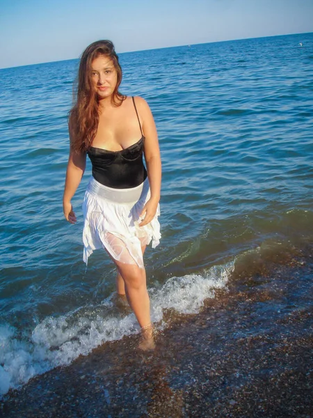 Arap genç bir kız, dolgun kalçalı, deniz kenarında dinleniyor, vücudunu gösteriyor, artı beden ölçülerinde bir kız.