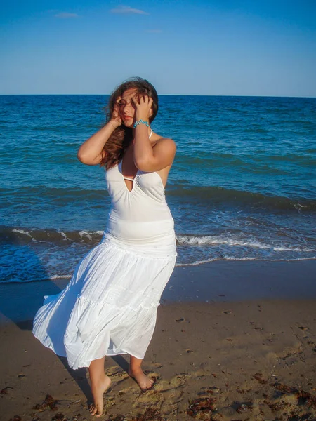 Arap genç bir kız, dolgun kalçalı, deniz kenarında dinleniyor, vücudunu gösteriyor, artı beden ölçülerinde bir kız.