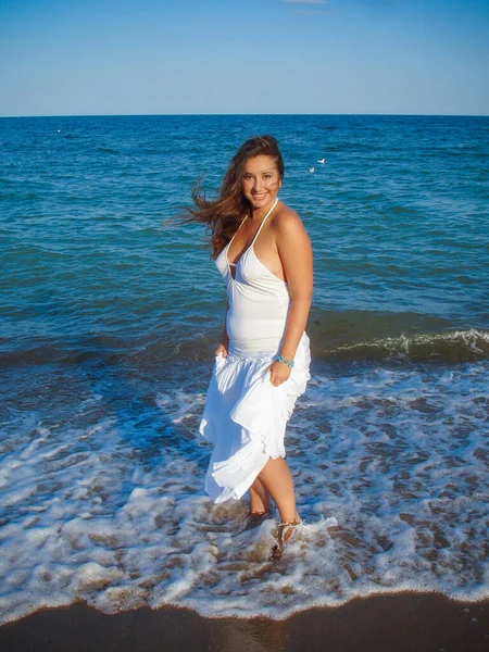 Arap genç bir kız, dolgun kalçalı, deniz kenarında dinleniyor, vücudunu gösteriyor, artı beden ölçülerinde bir kız.