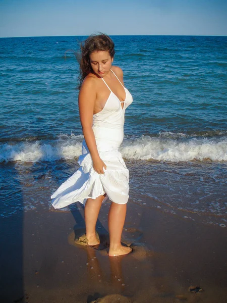 Arap genç bir kız, dolgun kalçalı, deniz kenarında dinleniyor, vücudunu gösteriyor, artı beden ölçülerinde bir kız.